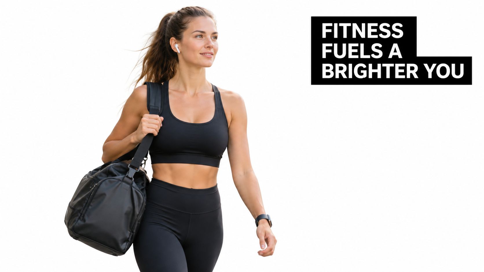 A fit young woman smiling while walking outdoors wearing black athletic wear and carrying a gym bag.