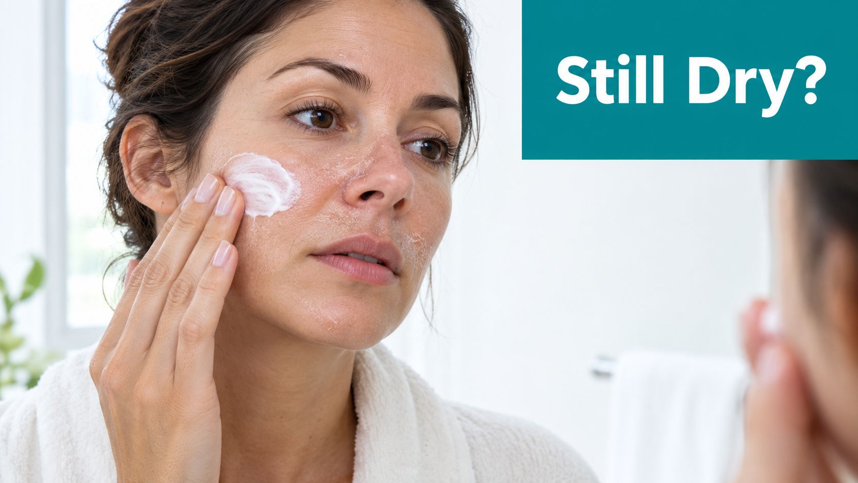 A woman applying white moisturizing cream to her face while looking at herself in a mirror.