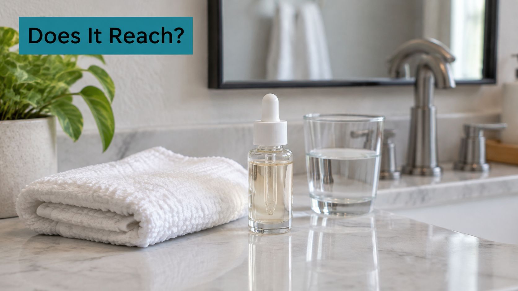 A glass serum bottle, a folded white towel, and a glass of water on a marble countertop.