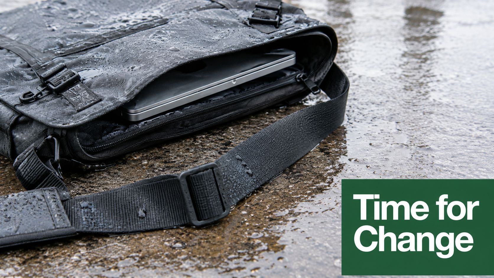 A durable, water-resistant eco friendly laptop bag sitting on wet pavement during a rainy day.