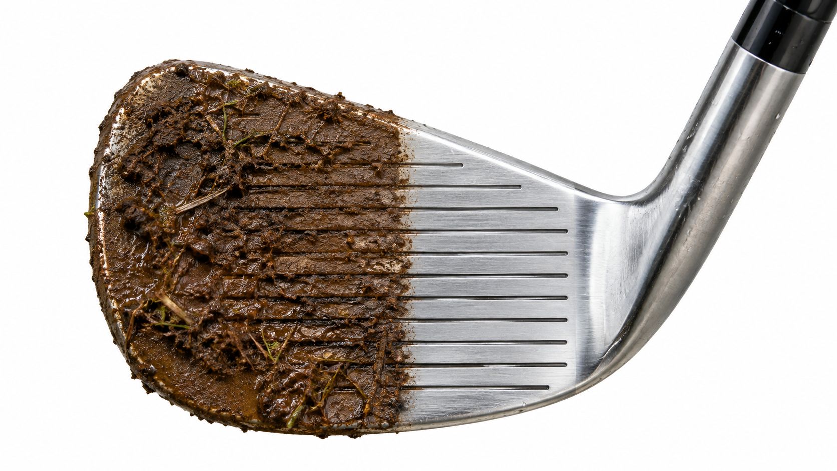 A close-up view of a golf club head with one half covered in mud and dirt.
