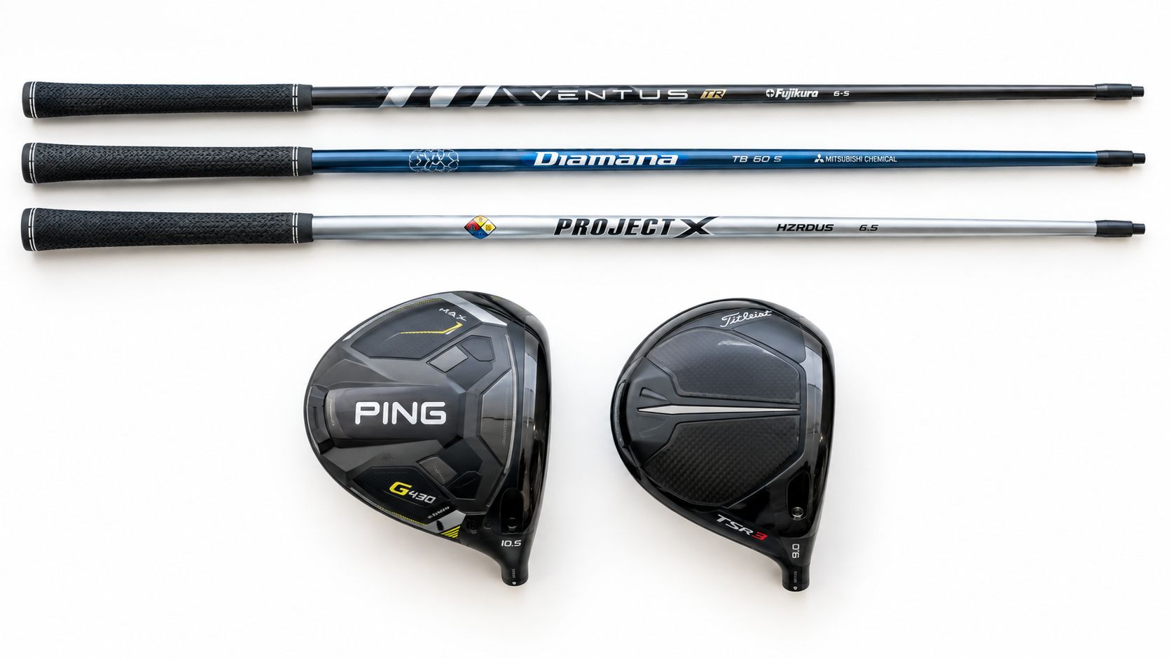 A collection of golf equipment featuring two driver club heads and three interchangeable graphite shafts on white.