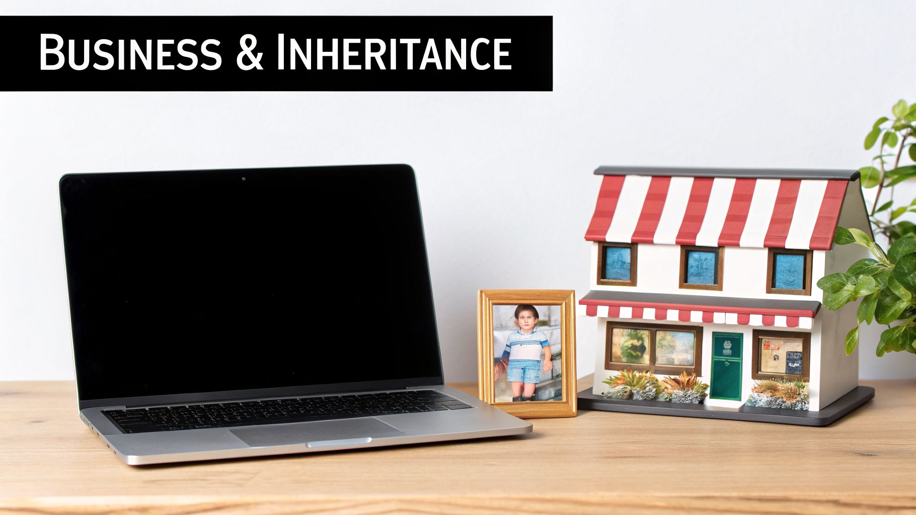 Laptop, child's photo, and miniature house model on a desk with 'Business & Inheritance' banner.