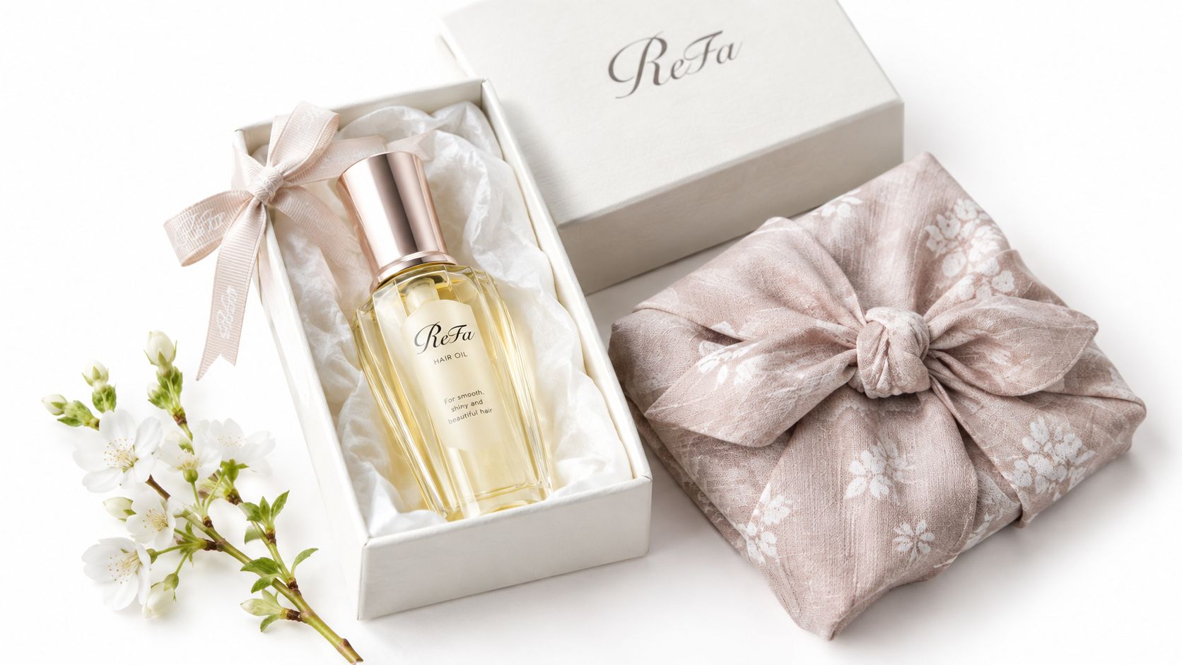 A ReFa hair oil bottle elegantly presented in a gift box with a floral ribbon and cherry blossoms.