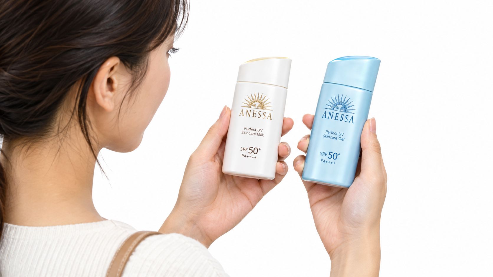 En kvinde holder og sammenligner hvid Anessa-mælkesolcreme og blå Anessa-gelsolcreme.