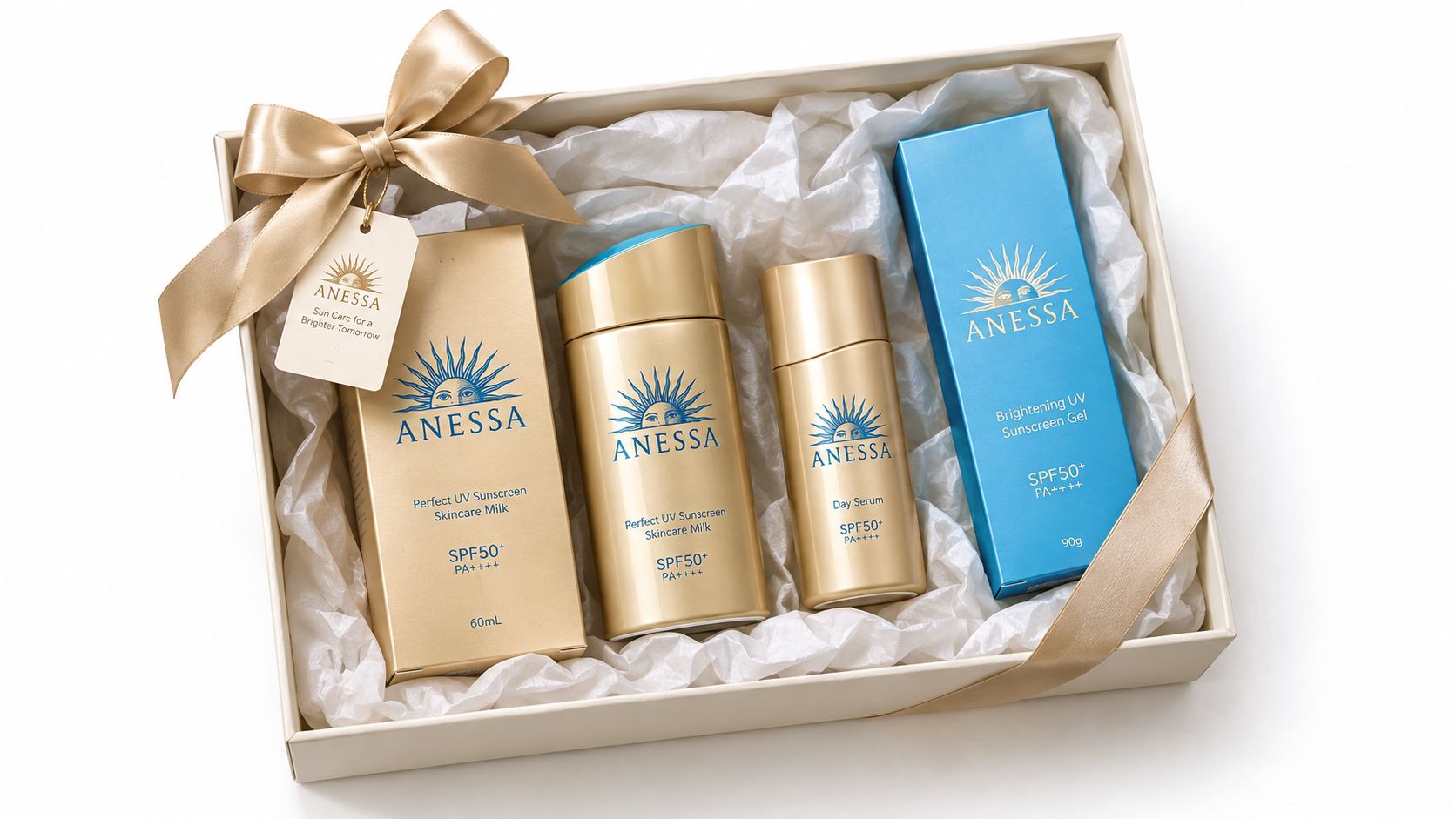 A gift box containing four Anessa skincare products including sunscreen milk and serum with a gold ribbon.