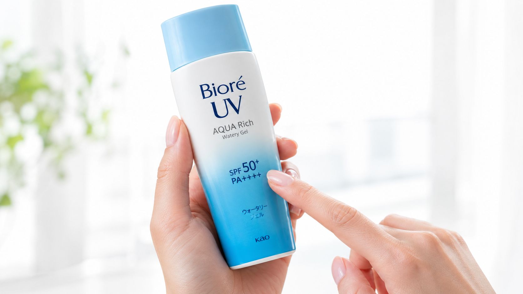 A woman's hand holding a bottle of Bioré UV Aqua Rich Watery Gel sunscreen in sunlight.