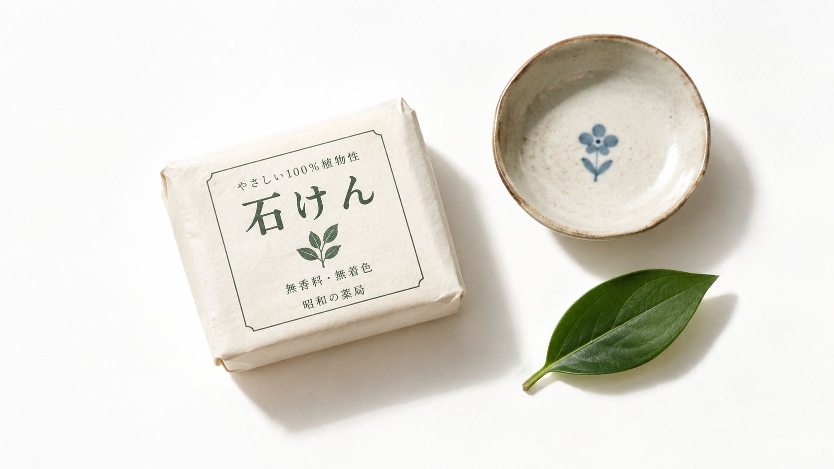 A wrapped bar of Japanese natural plant-based soap next to a small decorative bowl and a green leaf.