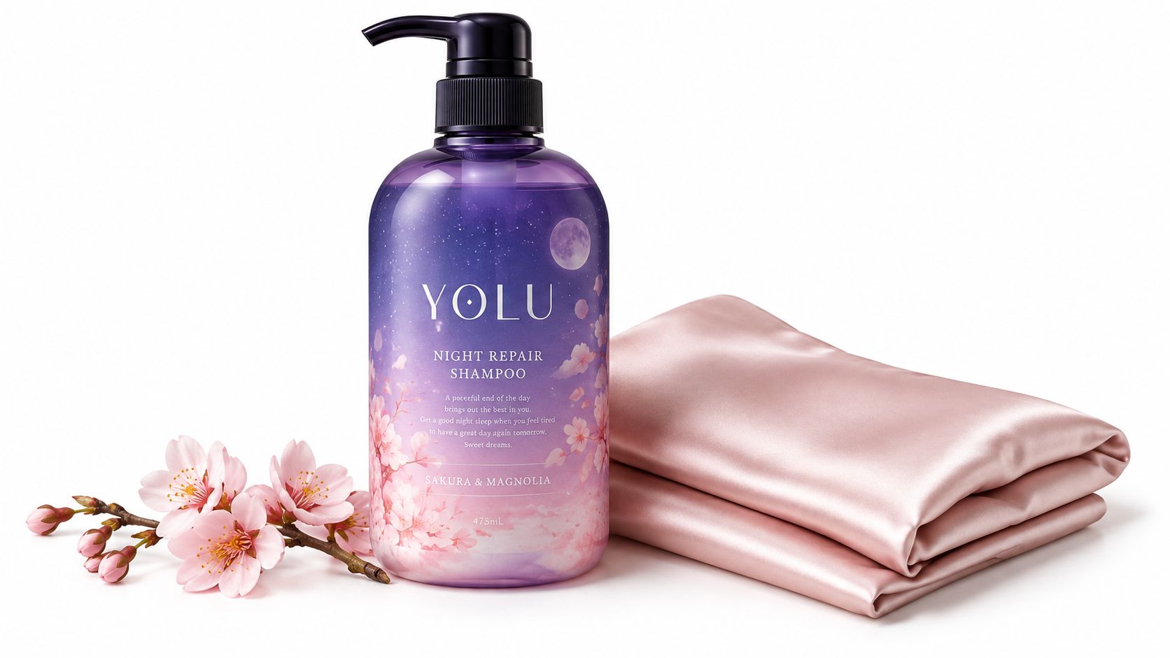 A purple bottle of Yolu Night Repair shampoo next to pink cherry blossoms and a silk cloth.