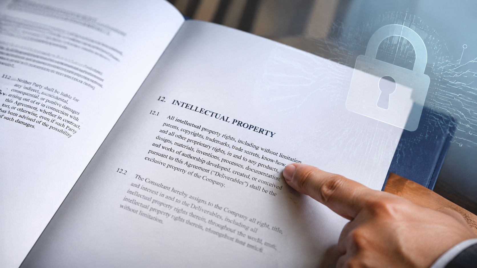 A close-up of a person's finger pointing at an intellectual property clause in a legal document.