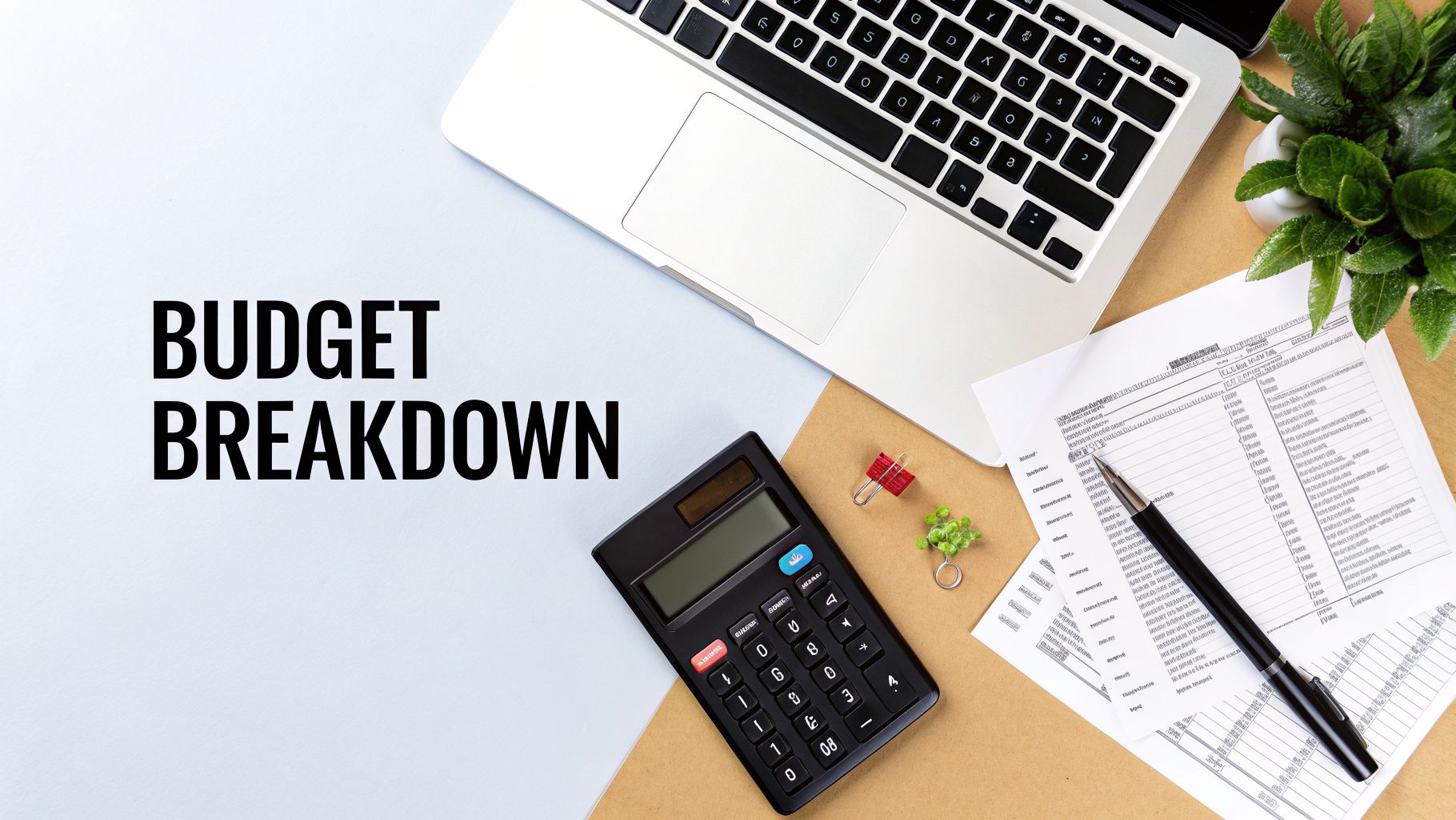 A flat lay of an office desk with "BUDGET BREAKDOWN" text, laptop, calculator, and financial documents.