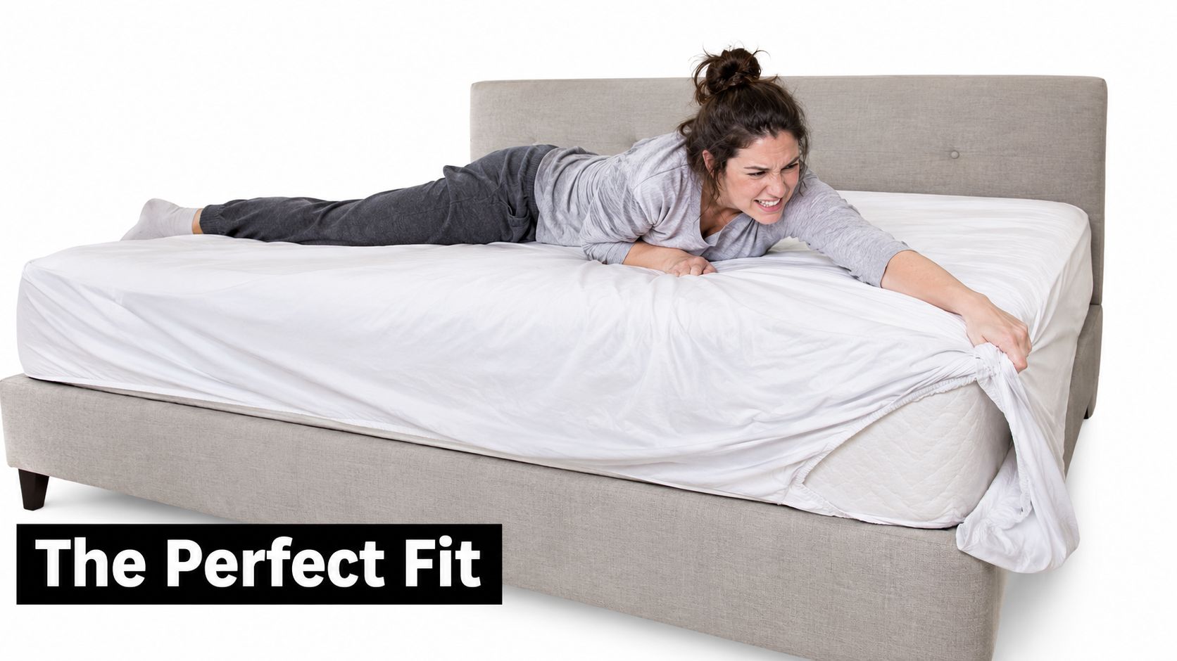 A frustrated woman struggling to pull a fitted sheet onto the corner of a large bed.