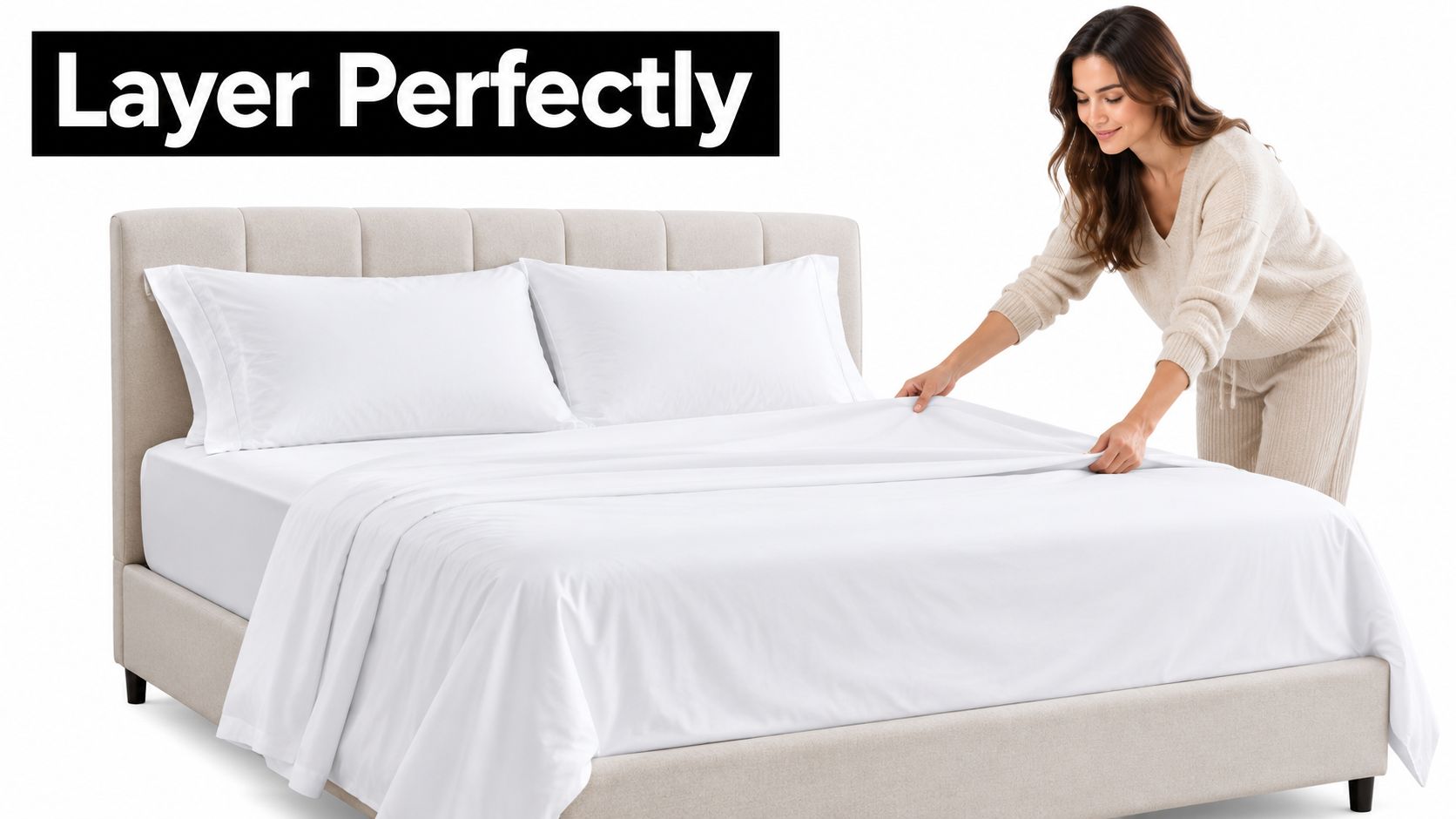 A woman making a bed with crisp white luxury hotel collection bedding on a neutral upholstered bed frame.