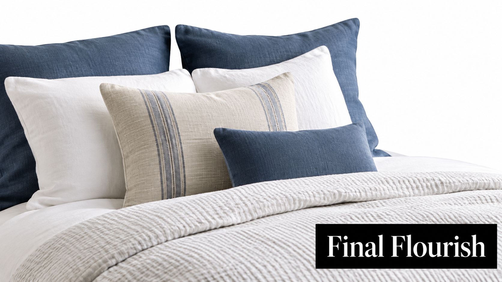 A cozy bed featuring layered white and blue decorative pillows atop a white textured quilt cover