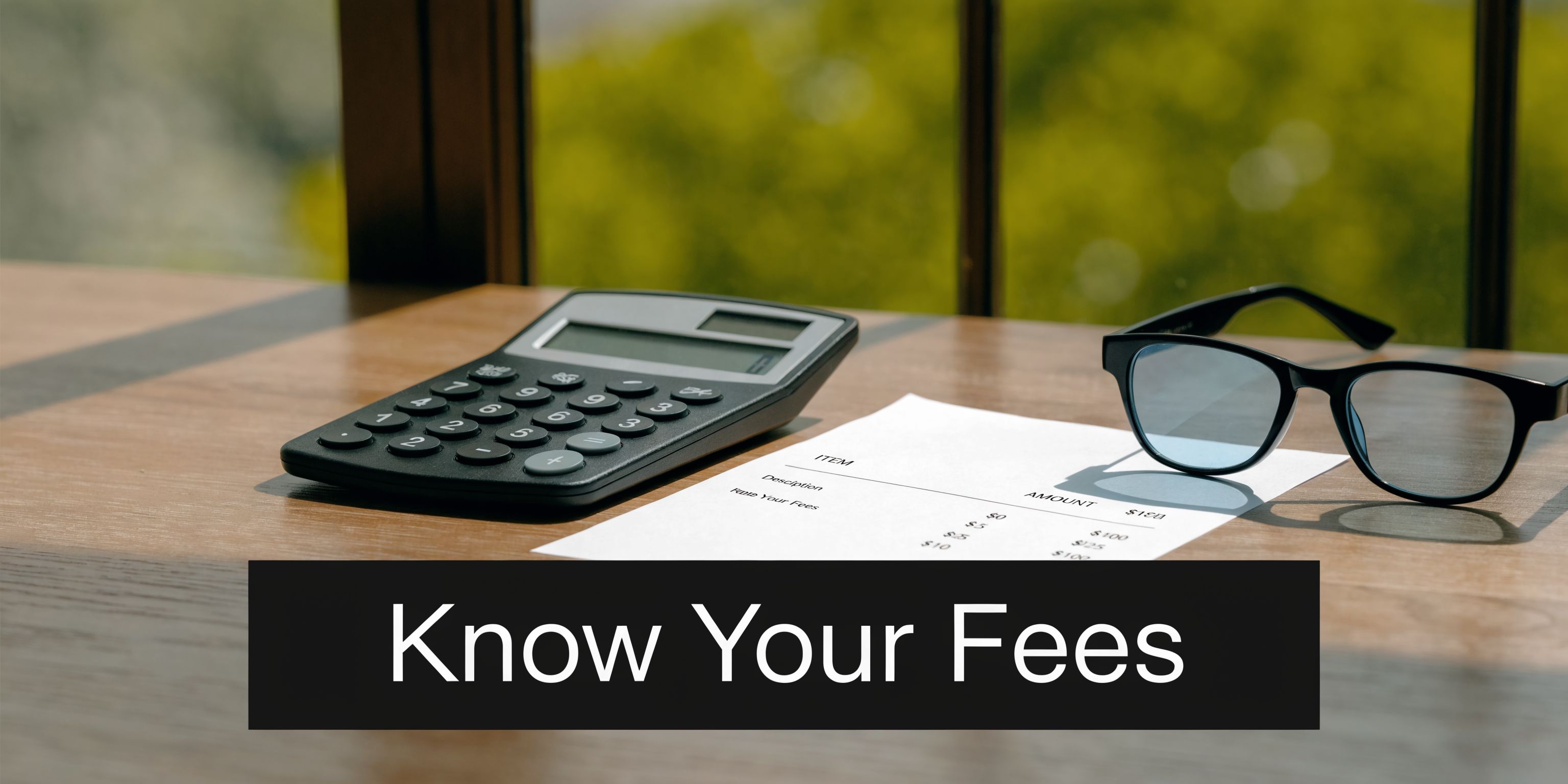 A black calculator and glasses sit on a wooden table next to a document about fees.