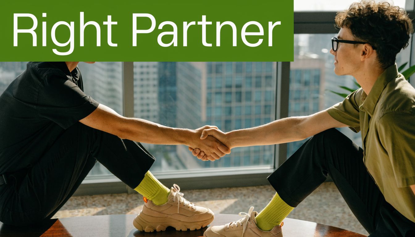 Two people shaking hands to symbolize a professional partnership in a brightly lit modern office setting.