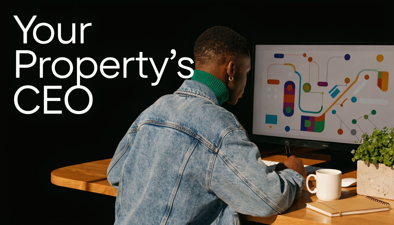 A young man wearing a denim jacket works at his desk, managing property operations on his computer.