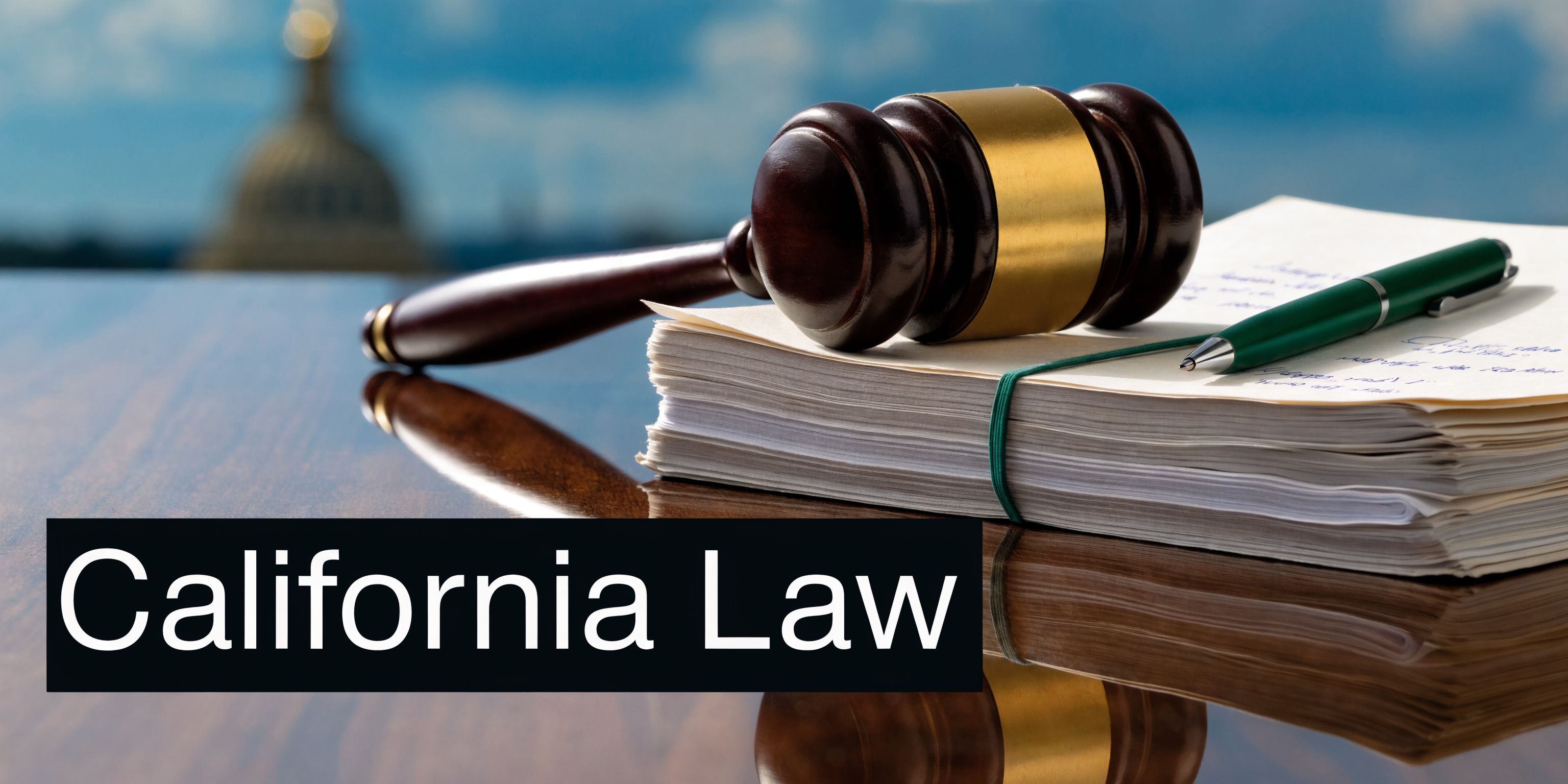 A wooden gavel resting on a stack of legal documents with a green pen on a table.