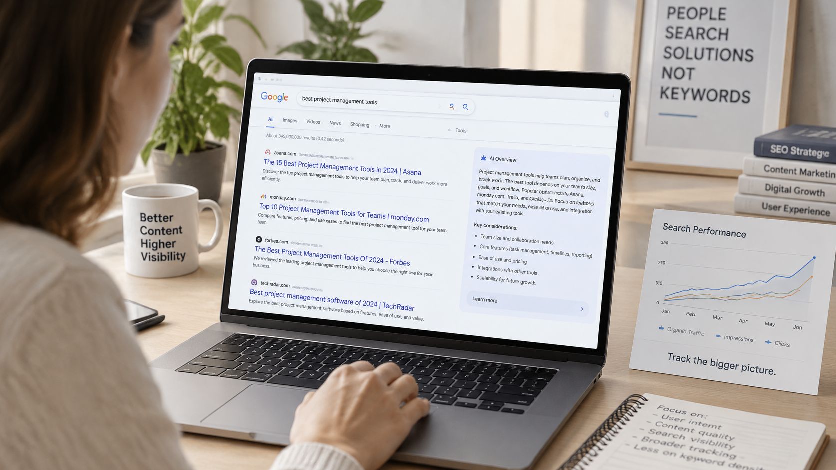 A person using a laptop to search for project management tools while sitting at a desk.