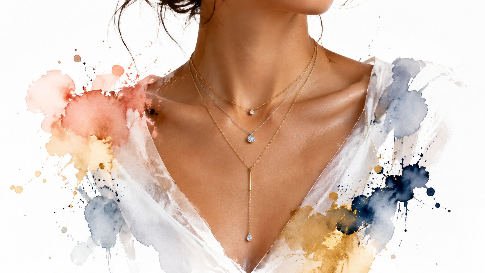 A close-up of a woman wearing three layered gold and silver necklaces against a watercolor background.