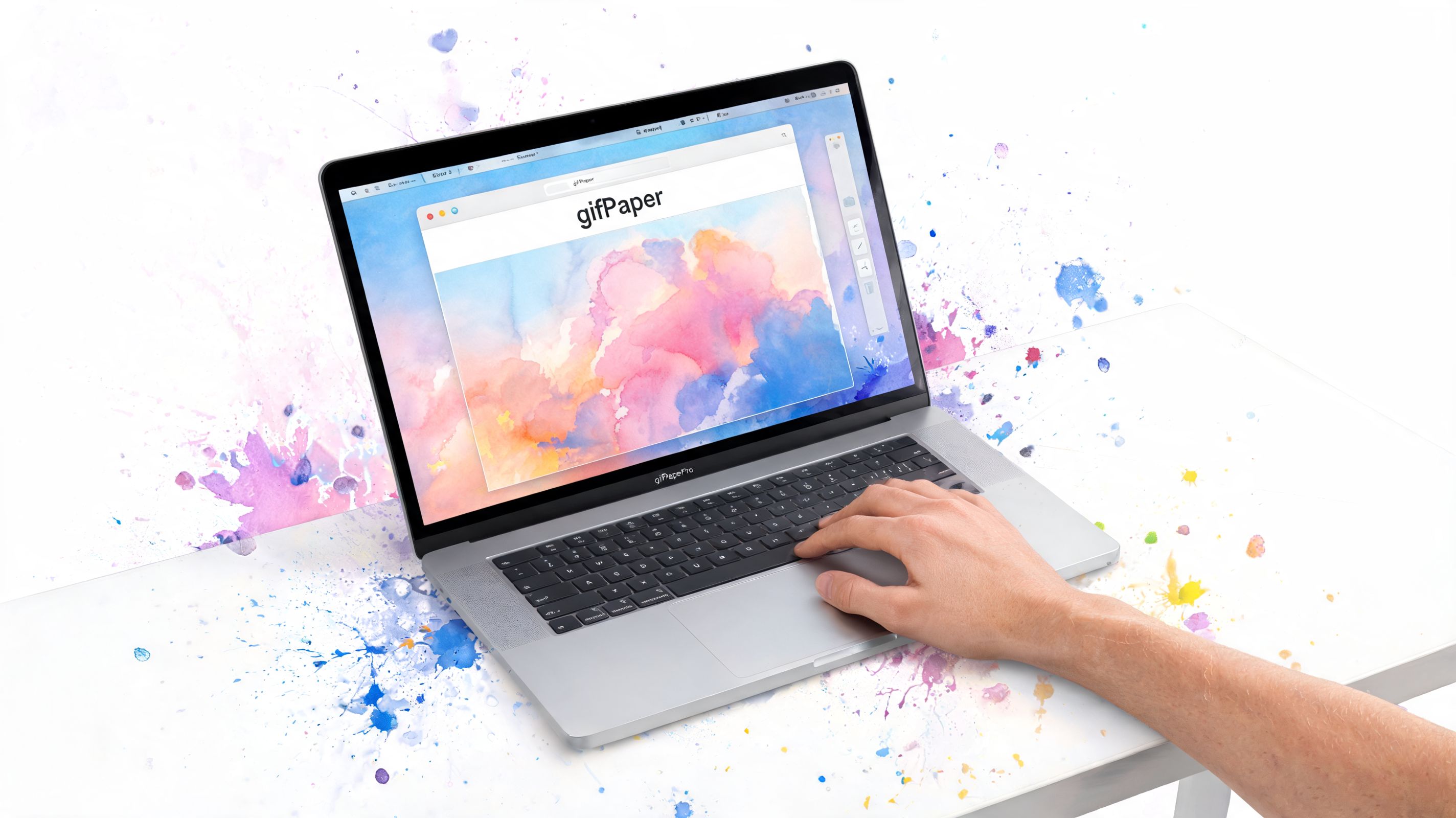 A hand interacts with a silver 13-inch MacBook Pro featuring colorful watercolor paint splatters on the screen.