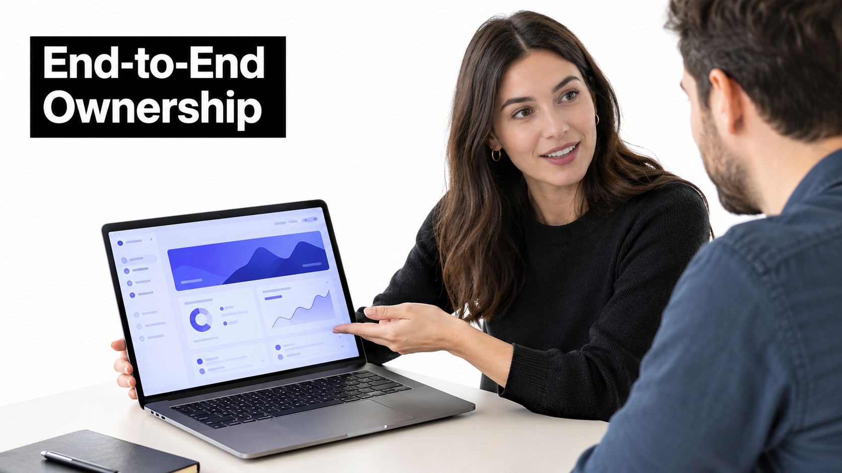A woman discussing data dashboard metrics on a laptop screen with a male colleague in an office.