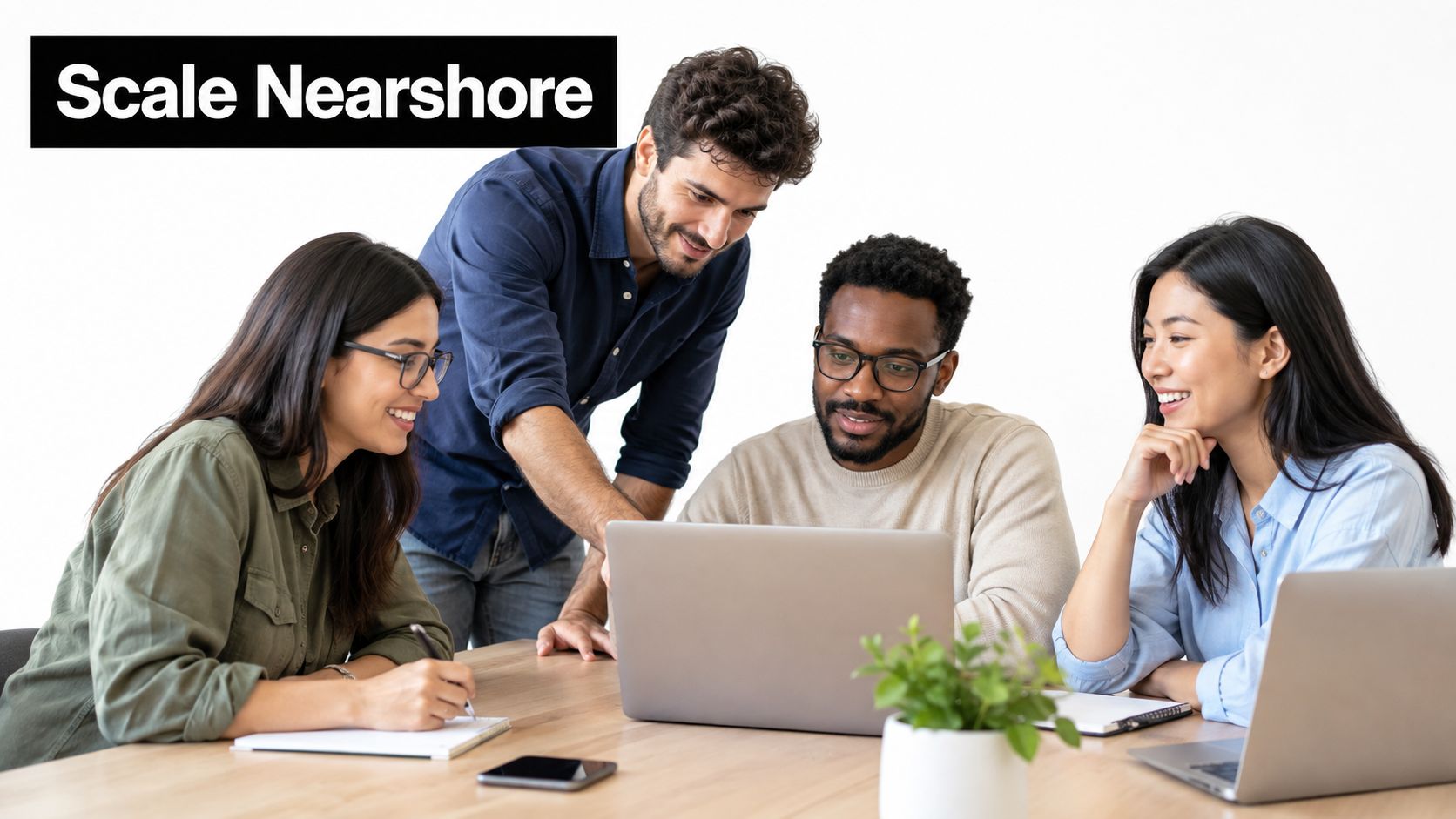 A diverse team of four professionals collaborating and discussing work around a laptop in an office setting.