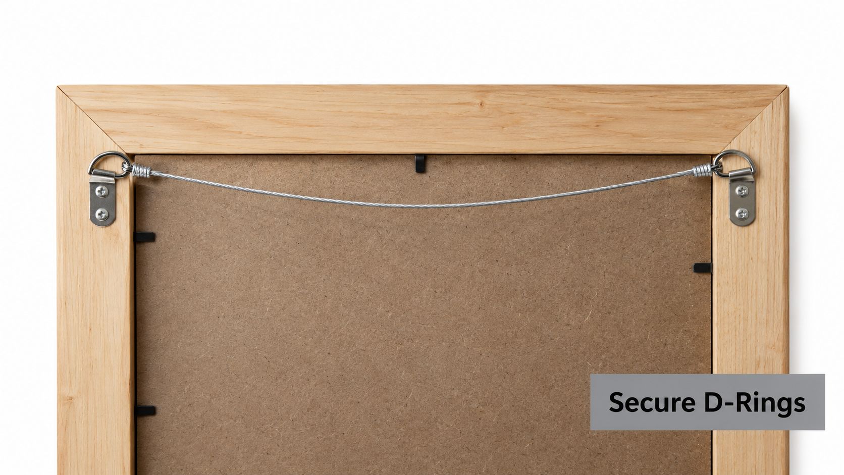 The back of a wooden picture frame showing a wire attached to two secure metal D-rings.
