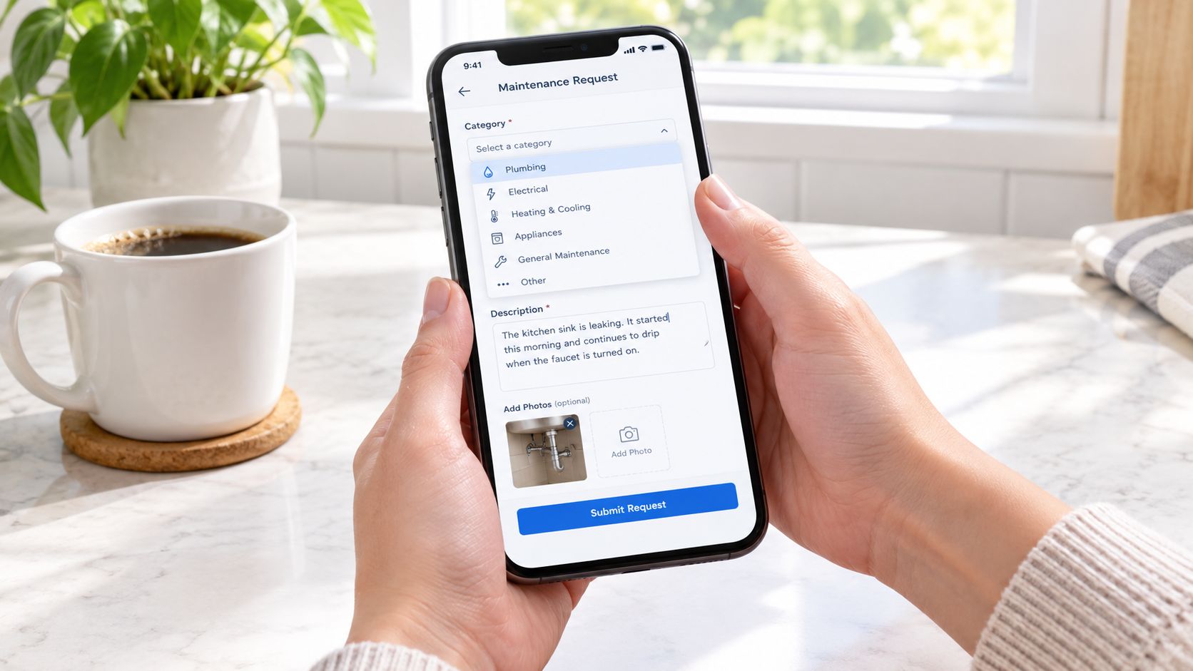 A person holding a smartphone displaying an online form to submit a property maintenance request.