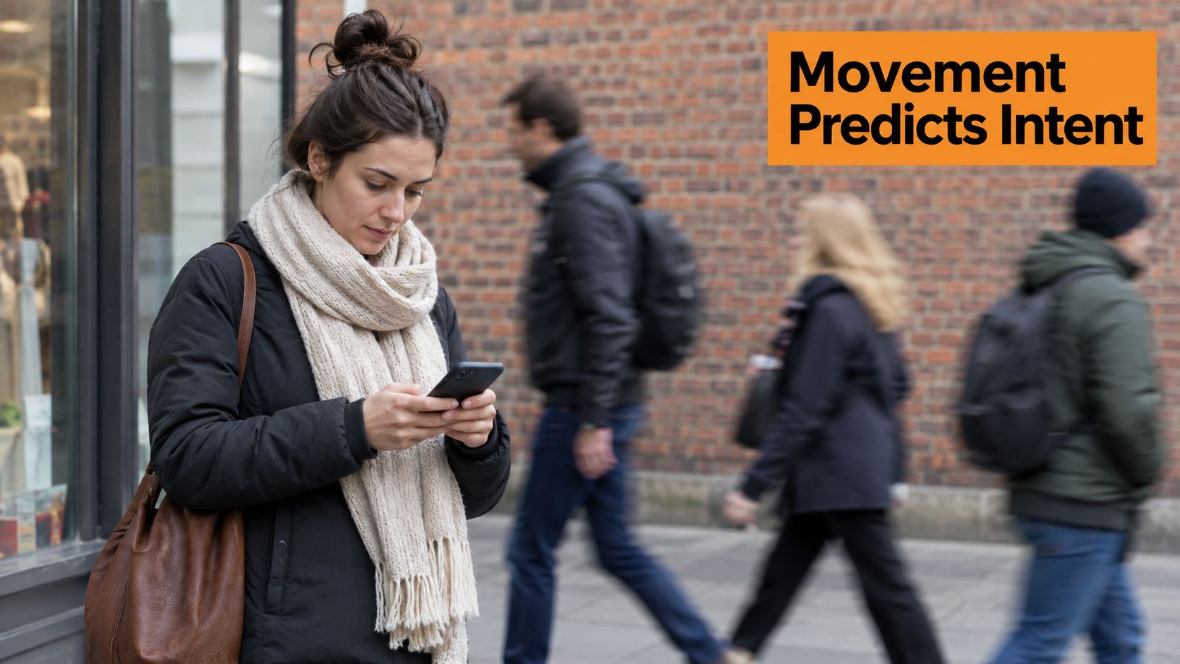 A young woman uses her smartphone on a busy street with blurry pedestrians walking in the background.