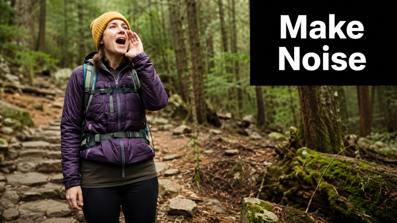 A woman in a purple jacket and yellow beanie hiking on a trail in bear country.