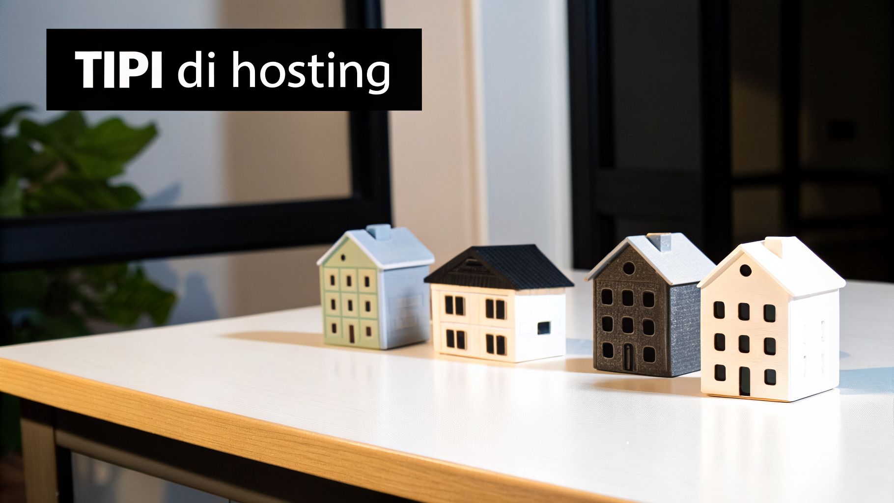 Quattro case in miniatura allineate su un tavolo bianco, con un banner nero che recita "TIPI di hosting".