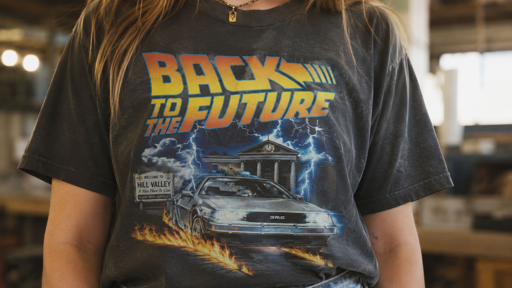 A person wearing a faded black t-shirt with a Back to the Future movie graphic design.
