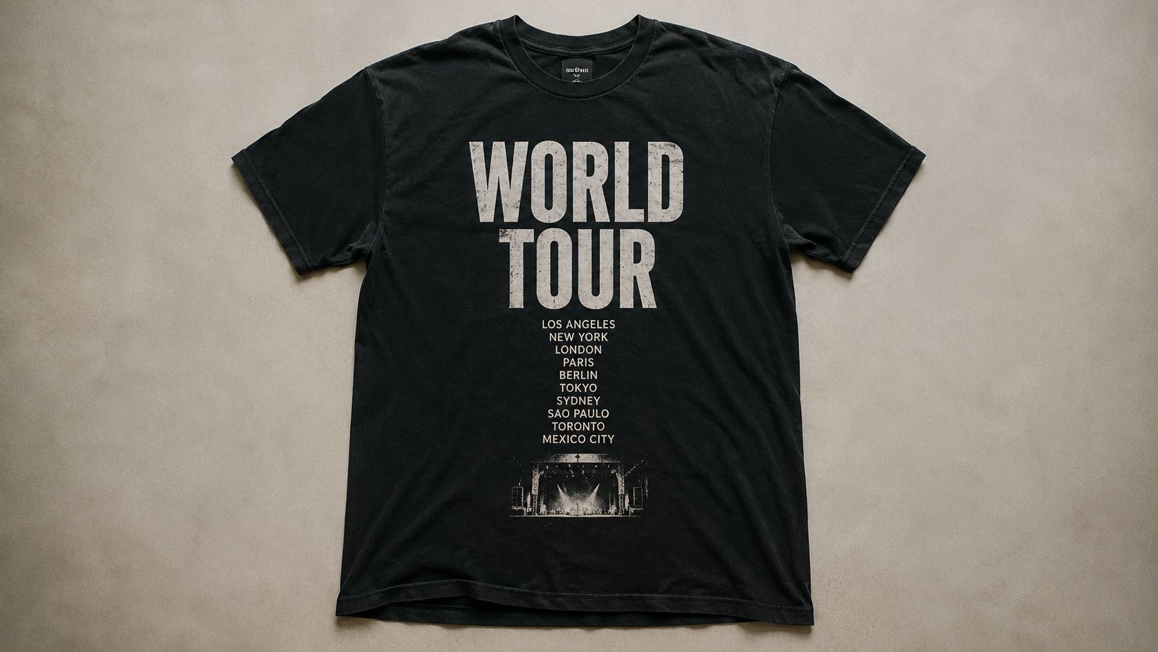 A black short-sleeved graphic t-shirt featuring the words WORLD TOUR in distressed white text over a list of global cities.