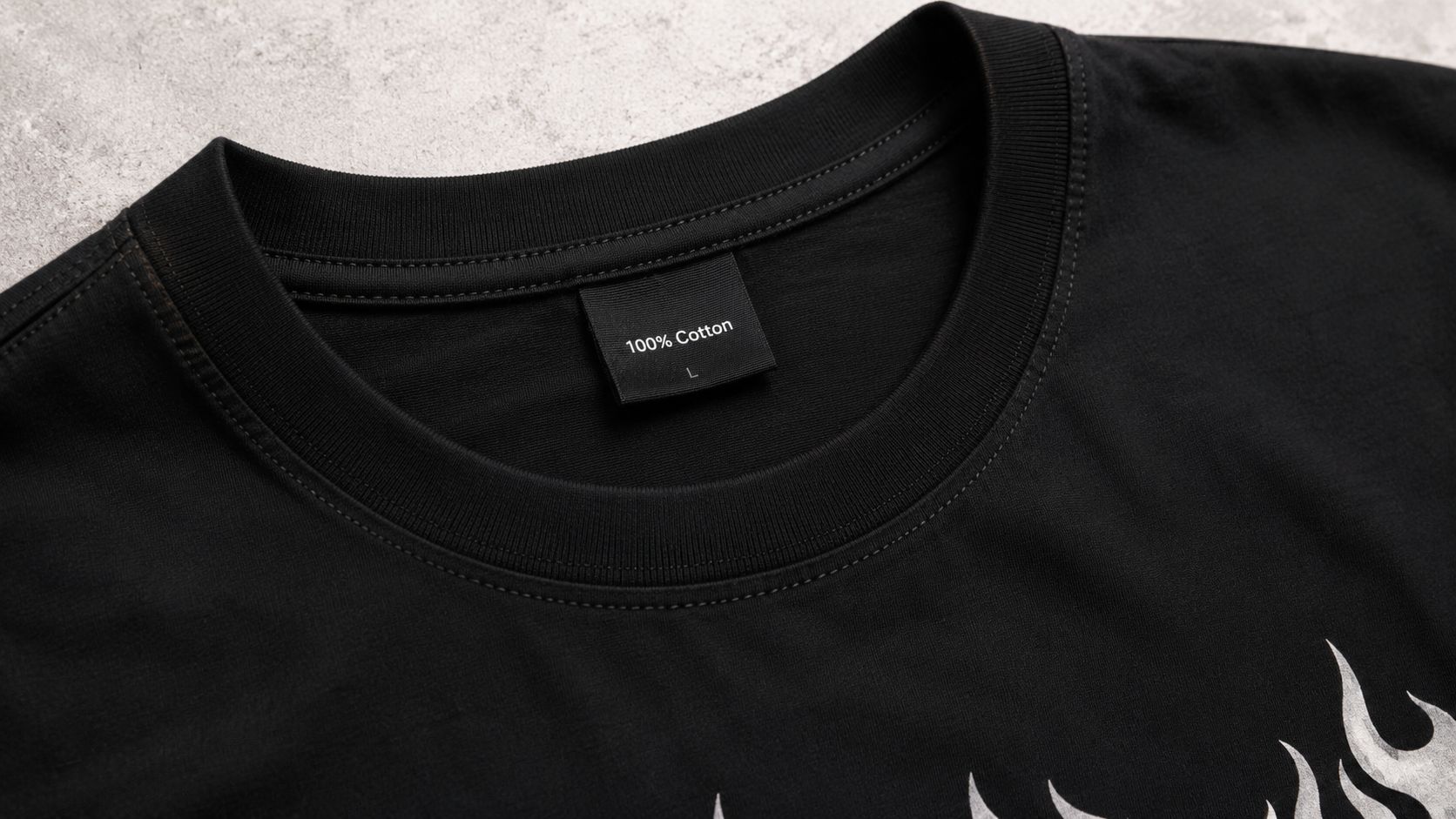 A close-up view of a black cotton t-shirt collar featuring a clothing size label marked size large.