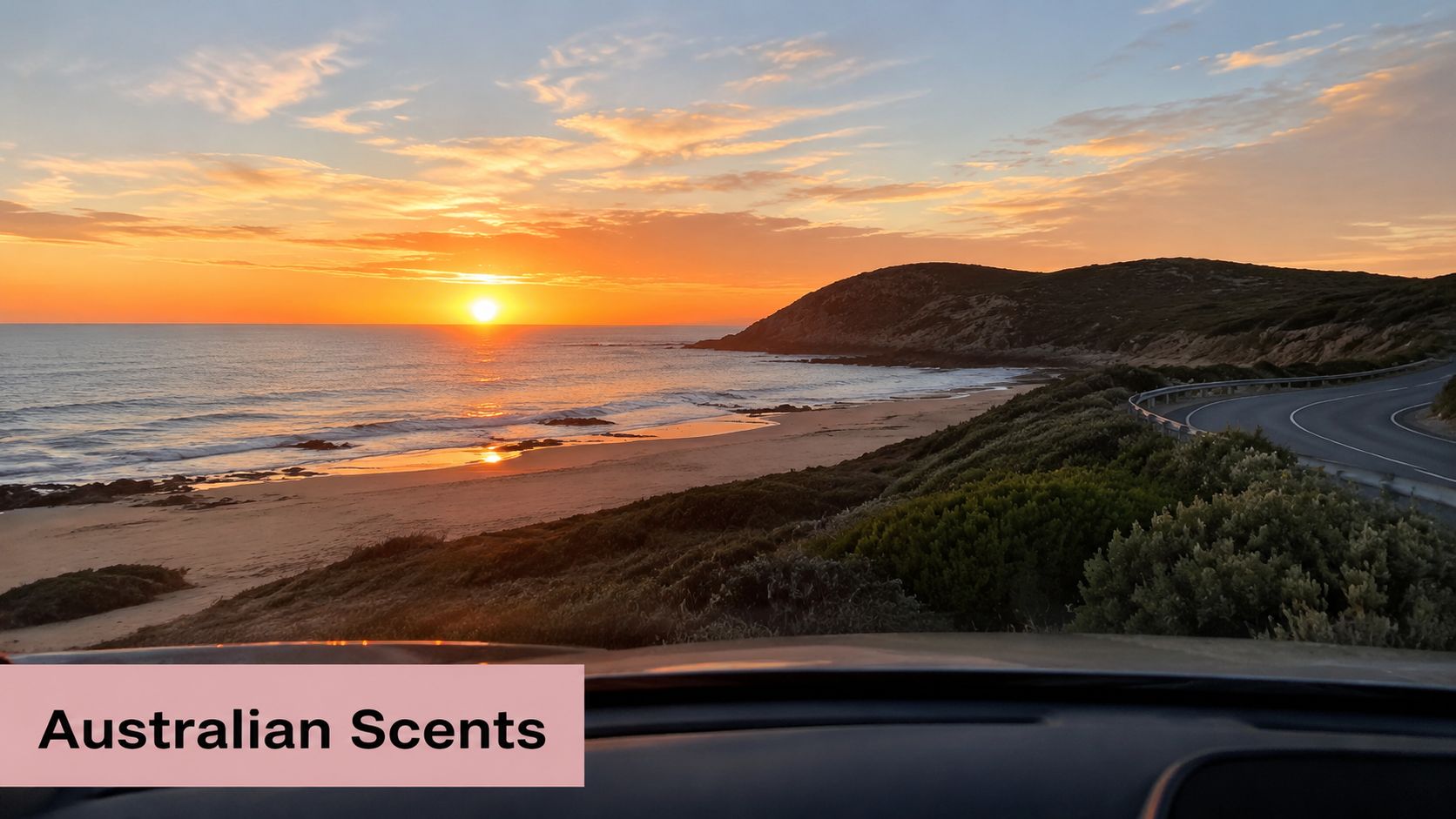 A breathtaking sunset over an Australian coastal beach view from inside a car dashboard.