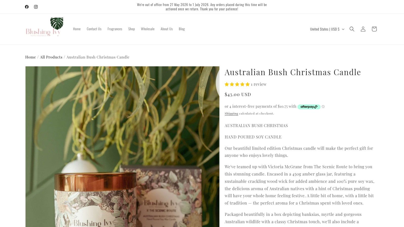A scented Australian Bush Christmas candle in a jar with its decorative packaging box on a table.
