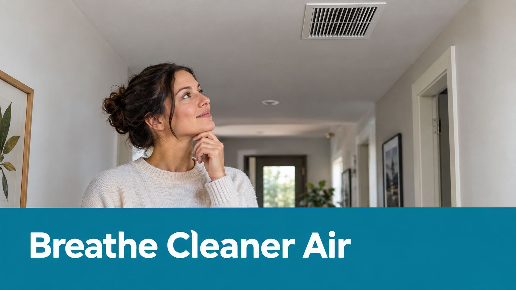A woman looks up thoughtfully at an air vent in a bright hallway, considering clean indoor air.